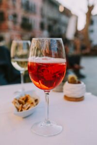 Aperol Spritz on a table in an outdoor setting with appetizers and warm ambiance.